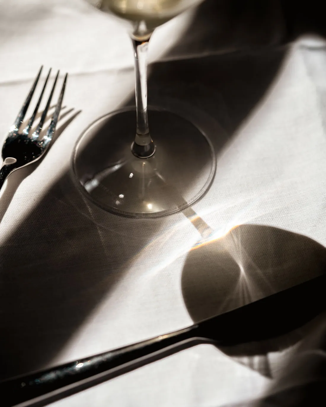 Verre à vin et couverts dans la lumière, salle de Double Impact
